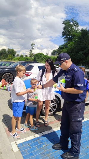 Policjant rozdaje dzieciom odblaski