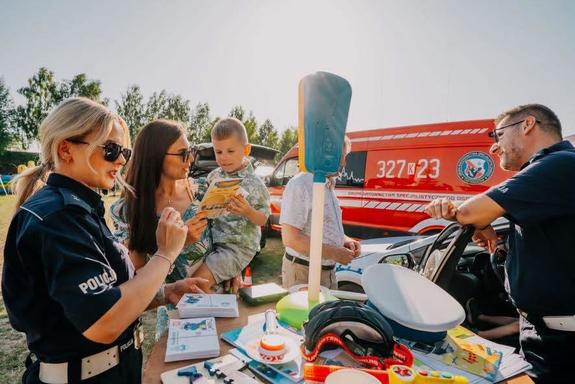 Policjanci i uczestnicy pikniku przy policyjnym stoisku