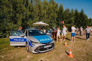 Policyjny radiowóz i policyjne stoisko przygotowane na piknik