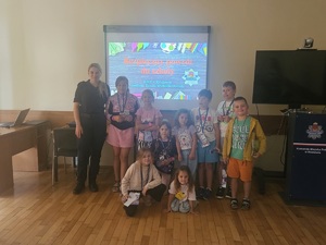 Policjantka i dzieci uczestniczące w półkoloniach