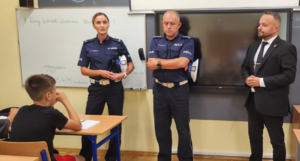 policjanci oraz Radny podczas prelekcji dla uczniów w sali lekcyjnej