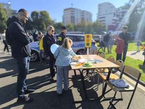 04 Policjantka opowiada dziecku i jej opiekunowi o przepisach ruchu drogowego