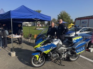 dwaj funkcjonariusze przy policyjnym motocyklu