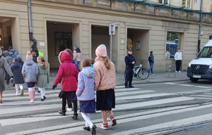 01 Policjant prewencji zabezpieczający bezpieczne przejście dzieci po przejściu dla pieszych
