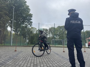 01 Policjantka nadzoruje dziecko na rowerze na egzaminie praktycznym