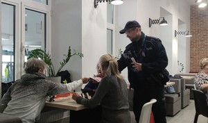 01 Policjant rozdaje ulotki seniorom