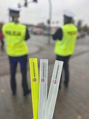 01 Opaski odblaskowe a w tle policjanci