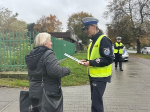 03 Policjantka wręcza pieszej opaskę odblaskowa