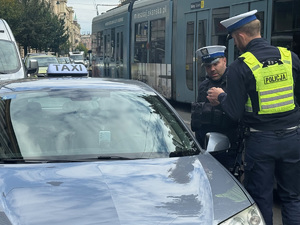 policjanci rozmawiają z kierowcą taksówki