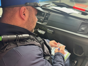policjant ruchu drogowego wypisuje mandat