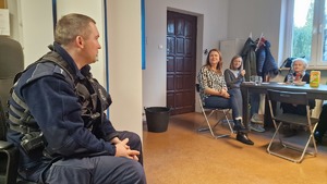 02 Policjant omawia tematy z uczestnikami spotkania