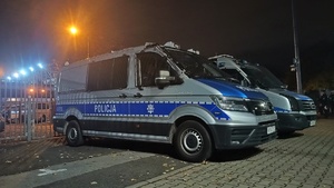 dwa oznakowane radiowozy zaparkowane przed stadionem