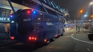 policyjny pojazd stojący przed bramą wjazdową przed jeden z sektorów na stadionie