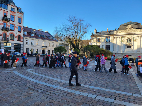 policjantka towarzysząca dzieciom w przemarszu kończącym kampanię