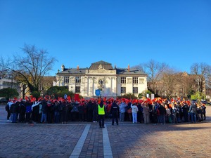 uczniowie na placu Szczepańskim tworzą z kartek uniesionych do góre czerwone serce