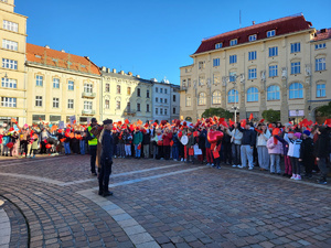 uczniowie zgromadzeni na placu Szczepańskim z czerwonymi kartkami w ręku