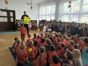 policjant pokazuje dzieciom kamizelke