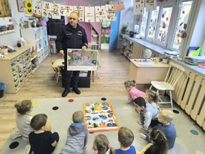 policjant drogówki pokazuje dzieciom obrazek