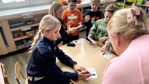 policjantka wypełnia z dziećmi kolorowanke