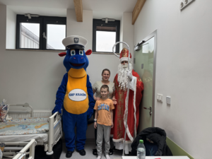 mikołaj i maskotka policyjna, pośrodku dziecko z mamą