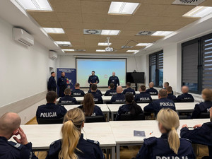 sala lekcyjna, słuchacze , ekran w tle