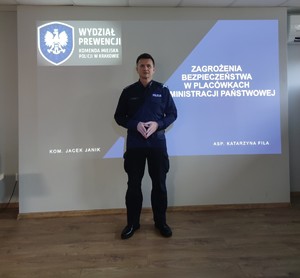 policjant stoi na tle ekranu