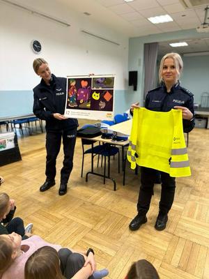 policjantka prezentuje kamizelke ostrzegawczą