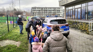 dzieci na zewnątrz, w tle radiowóz