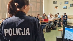 1 Policjantka prowadzi prelekcje, w tle uczniowie