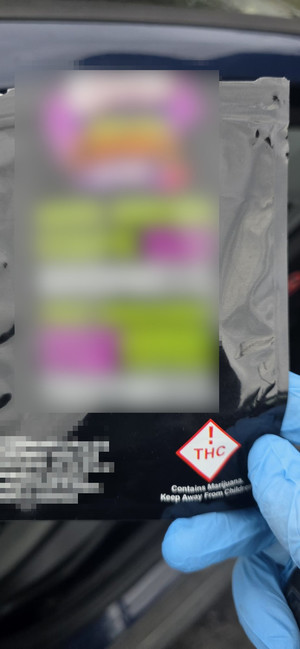 ręka w gumowej rękawczicze trzyma opakowanie