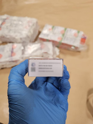 ręka w gumwej rękawiczce trzymająca pudełko