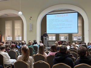 Policjant w siedzibie NBP prowadzi wykład dla uczniów