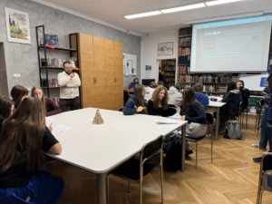 uczniowie w bibliotece, w tle ekran