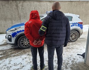 Policjanci kryminalni prowadzą zatrzymanego złodzieja laptopa