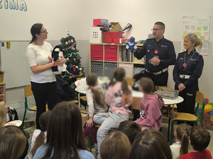 uczniowie w sali lekcyjnej, obok policjant i policjantka