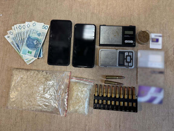 zabezpieczone narkotyki w woreczkach foliowych, gotówka, amunicja, wagi elektroniczna i telefony komórkowe