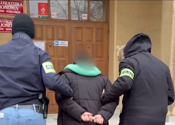 dwóch nieumundurowanych policjantów prowadzi zatrzymaną do prokuratury