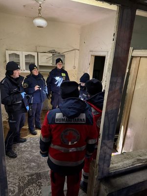 umundurowani policjanci, funkcjonariusze Straży Miejskiej oraz przedstawiciele Polskiego Czerwonego Krzyża podczas wizyty w jednym z budynków