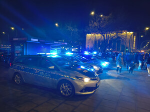 Oznakowane radiowozy z włączonymi sygnałami świetlnymi w godzinach nocnych w rejonie ul. Focha