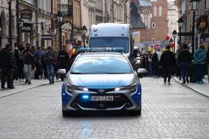 oznakowany radiowóz jadący przed osobami biorącymi udział a marszu