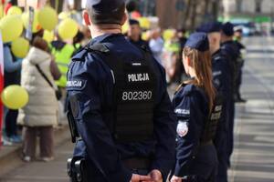 umundurowani policjanci obserwujący osoby biorące udział w marszu