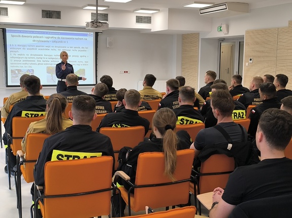 policjantka prowadzi w sali szkolenie dla strażaków