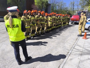 strażacy słuchają wskazówek policjantki podczas prowadzonego szkolenia