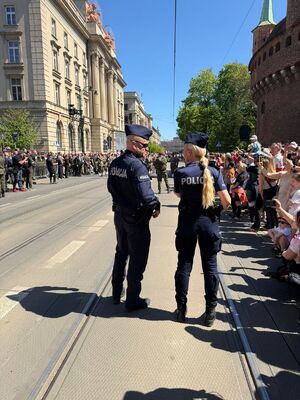 dwoje umundurowanych policjantów stojących na ulicy Basztowej pilnuje porządku w rejonie odbywających się uroczystości