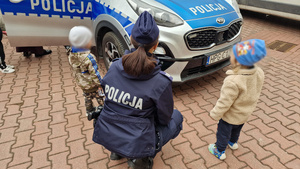 Policjantka rozmawia z dziećmi przy radiowozie