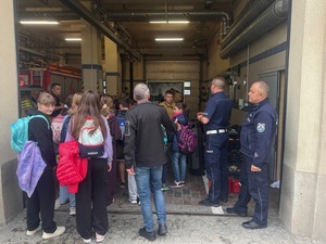 policjanci towarzyszą uczniom podczas wizyty w Straży Pożarnej