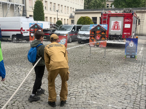 uczeń wężem strażackim próbuje trafić w wyznaczony cel