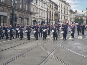 umundurowani policjanci idący przed grupą osób biorącą udział w marszu
