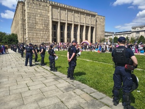 umundurowani policjanci stojący przed Muzeum Narodowym obserwujących zgromadzone tam osoby