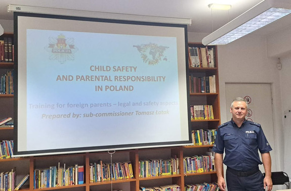 policjant prowadzący spotkanie dla rodziców uczniów szkoły będących obcokrajowcami